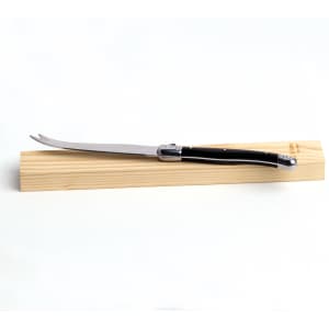 A Fetta cheese knife with a stainless steel blade and a black handle, resting on a wooden board.