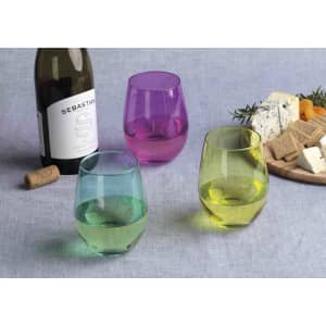 A wine bottle with three coloured glasses—green, yellow, and purple—alongside a cheese platter with crackers and cheese.