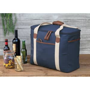 A navy cooler bag with beige straps sits next to several bottles of wine and beer, and a jar of snacks.
