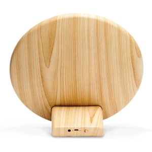 A round Bluetooth speaker featuring a wood-like finish, set on a small rectangular base with controls.