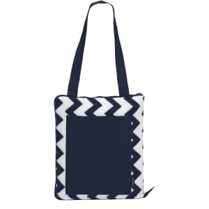 A navy and white chevron-patterned outdoor blanket with a zippered pocket and shoulder straps. It has a logo.
