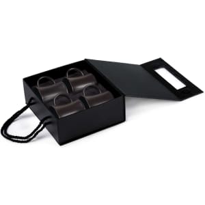 A black rectangular box containing four green espresso cups, with a handle, inside.