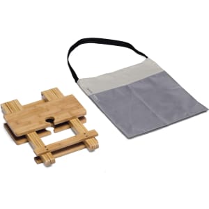 A bamboo table with a grey carrying bag. The table features a centre hole, ideal for leisure use.