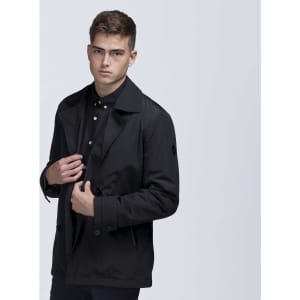 A black trench coat jacket with a stylish collar, featuring a logo on the sleeve and modelled by a man.