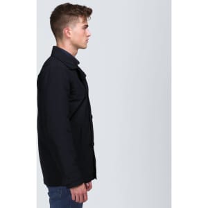 A black trench coat with a collared neckline, featuring a side view of a male model. The coat has buttons and a sleek design.