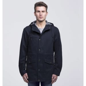 A navy blue twill jacket with a hood, featuring pockets and a grey lining, worn by a model.