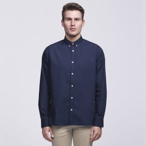 A navy button-up shirt with a collar, featuring a front pocket and a logo on the chest.