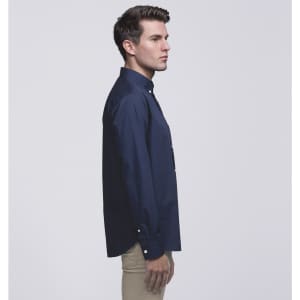 A navy button-up shirt displayed on a model from the side, featuring a collar and a logo.