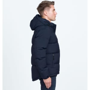 A side view of a navy blue puffer jacket featuring a hood and a logo. The jacket has a padded design.