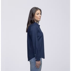 A side view of a woman wearing a navy button-up shirt with long sleeves and a collar. The shirt has a logo.