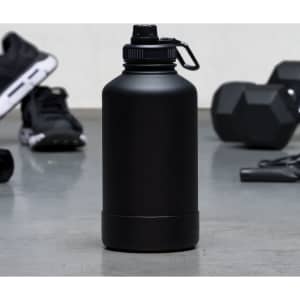 A drink bottle in matte black with a secure cap, set against a gym background of weights and workout gear.