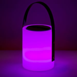 A purple speaker lamp with a glowing surface and a black handle, set against a dark background.