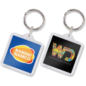 A square key ring featuring two sides, one with a colourful logo and the other with a vibrant design.