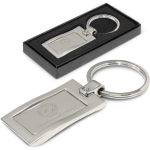 A silver metal key ring with a sleek rectangular design, presented in a black gift box.