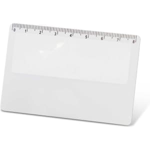 A card magnifier with a ruler along the top edge and a clear, smooth surface.