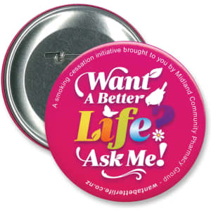 A round, 90mm button badge in vibrant pink with a silver backing and a logo.
