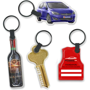 A collection of four novelty key rings, featuring a car, a wine bottle, a key, and a vest, all on black rings.