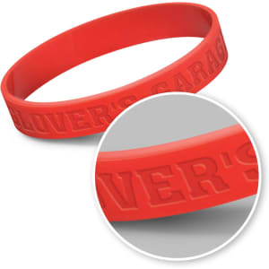 A red silicone wristband with embossed text and a circular inset showing the detail of the band.