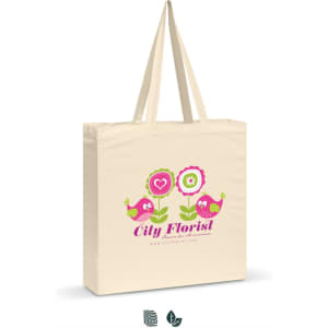A beige cotton shoulder tote with a playful floral and bird design, featuring a logo.
