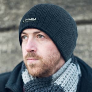 A Nebraska Cable Knit Beanie in black, featuring a subtle logo and a textured knit design.