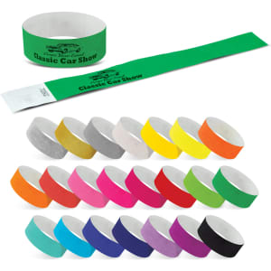 A variety of Tyvek event wristbands in multiple colours, including green, pink, yellow, and grey. Some feature a logo.