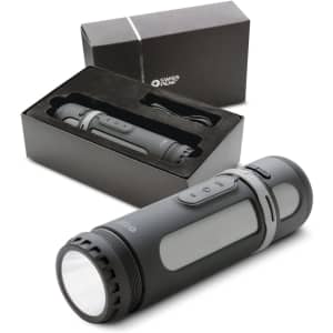 A grey 4-in-1 speaker from Swiss Peak, displayed with its packaging and charging cable.