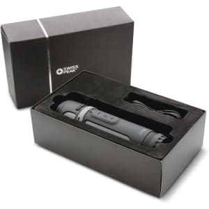 A sleek black and grey speaker packaged in a black box, complete with a cable inside. The box features branding.