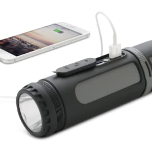 A black, cylindrical flashlight with a USB port for charging devices, alongside a smartphone connected to it.