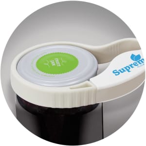A white jar and bottle opener with a logo, positioned on a jar lid, featuring a green circular label.