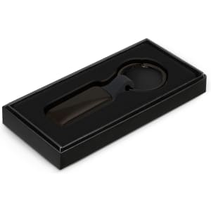 A rectangular black key ring presented in a black box with an insert. The key ring includes a logo.