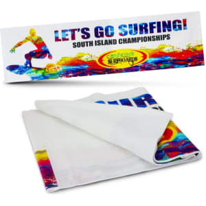 A folded white towel featuring a vibrant, multi-coloured surf design and a logo.