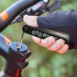 A multi-tool set in a hand, featuring a variety of tools, with a black and silver design.