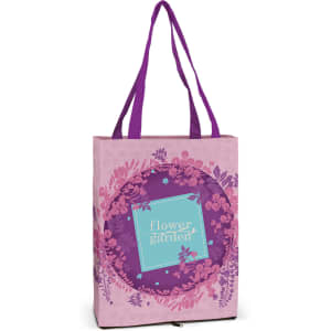A pink tote bag featuring a floral design with purple accents and sturdy purple handles. It has a logo on the front.