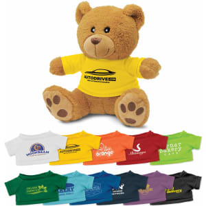 A brown teddy bear plush toy wearing a yellow shirt, with various coloured shirts displayed below.