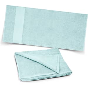 A soft, light blue beach towel displayed flat and partially folded, featuring a textured surface and a smooth edge.