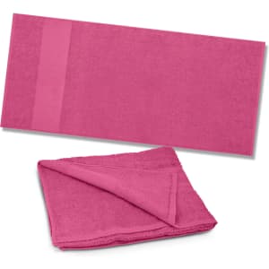 A vibrant pink Dune Beach Towel folded and laid out flat, featuring a soft, plush texture ideal for leisure activities.