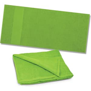 A vibrant green Dune Beach Towel lies flat, while a folded version of the same towel showcases its soft texture.