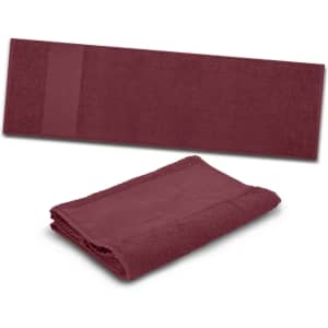 A maroon gym towel featuring a folded design and a textured strip on one side, with a logo visible.