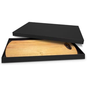 A wooden serving board with a round handle inside a black box. The board features a natural wood finish.