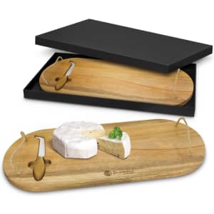 A wooden cheese board presented with a knife, featuring a black box packaging. The board has a natural finish.