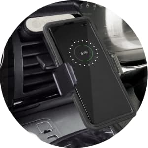 A black wireless charging phone holder mounted on a car dashboard, with a phone displaying a charging indicator.