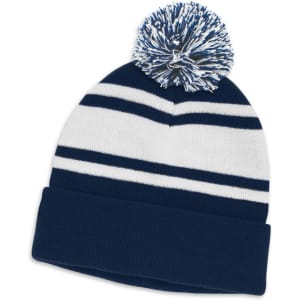 A navy and white striped beanie with a large pom pom on top and a folded cuff. Features a branding logo.