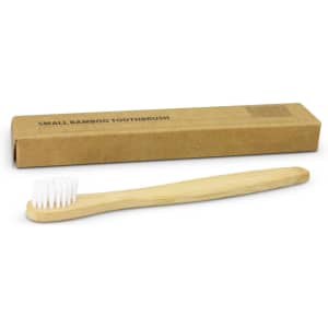 A bamboo toothbrush with a light wooden handle and white bristles, alongside a brown cardboard box.