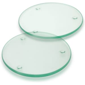 A set of two round glass coasters, transparent with a slight green tint and raised dots on the underside.