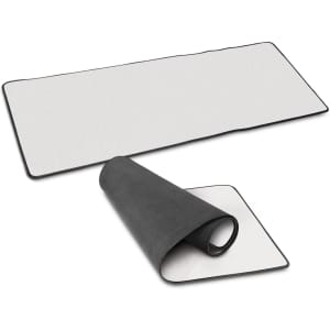 A Jumbo Desk Mat in white with a black border, displayed flat and rolled up partially to show both sides.