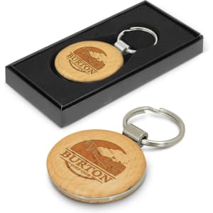 A round wooden key ring with a metal keychain, presented in a black gift box. Features a logo on the wooden surface.