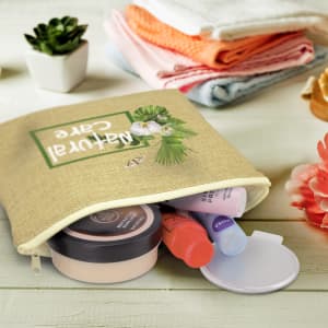 A natural-coloured cosmetic bag containing various skincare products and a compact. Features a logo on the front.