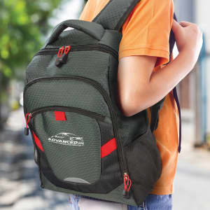 A green backpack with red accents is worn on a person's back, featuring a logo on the front.