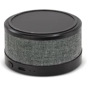 A round wireless speaker and charger with a textured grey fabric exterior and a sleek black top.