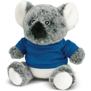 A grey koala plush toy wearing a blue shirt, featuring soft fur and large ears. It has a subtle branding logo.